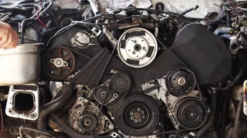 Mechanic Checking Engine Parts In Repair Shop