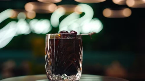 freshly prepared black alcoholic cocktail rotates on the bar counter in the bar-club