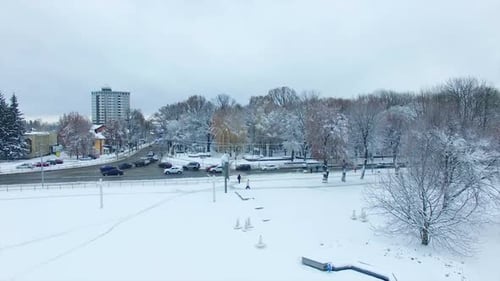Square in the city covered with snow carpet. Transport moves by the cleaned up roads.
