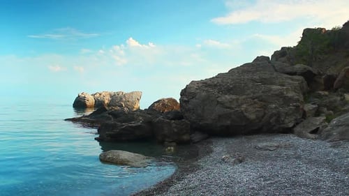 Crimean Pebble Beach with Turquoise Water Coastal Boulders Against Clear Sky Calm Sea Scenic Cliffs