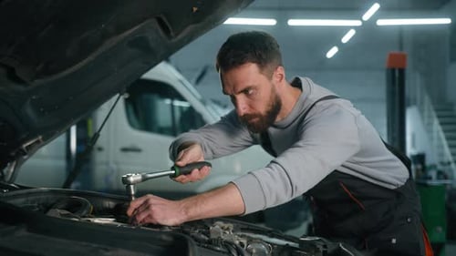 Man Repairing Car Engine in Garage