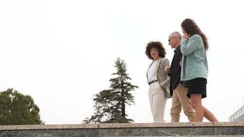 Confident Business People Walking and Discussing Outside Office