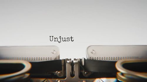 Old mechanical typewriter typing Unjust Treatment in a close-up view.