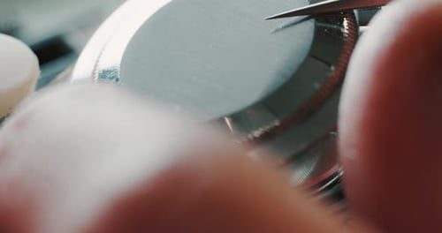 Slow motion close up of a professional watchmaker repairer working on a luxury mechanism watch gea