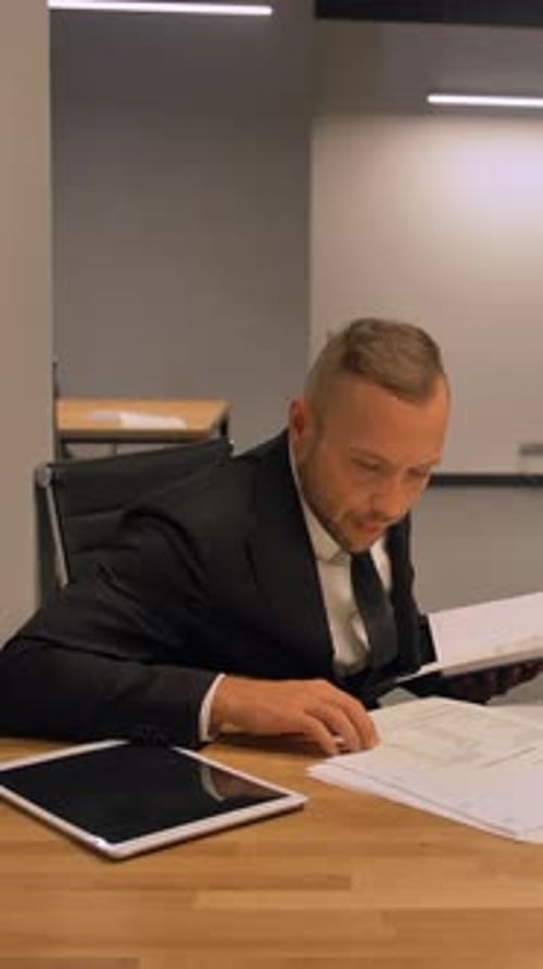 Professional Man Working at Desk with Tablet and Papers