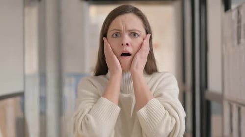 Worried woman reacts with shock and concern indoors