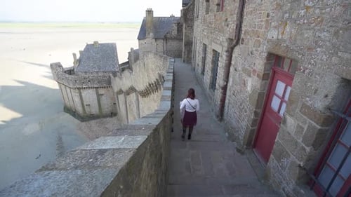 Woman Walking down stairs at Mont Saint Michel Walled Medieval City France