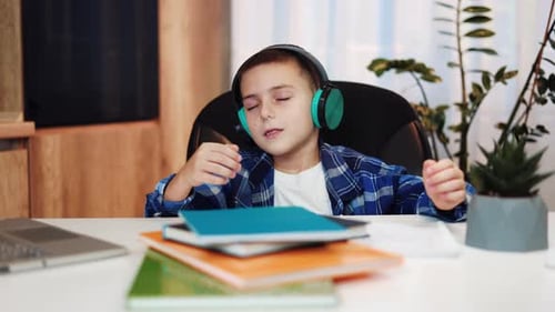 Boy with Headphones Listening at Desk