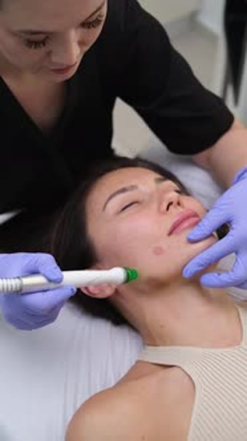 Cosmetologist Beautician Using Aqua Peeling Device During Procedure at Cosmetic Dermatology Clinic