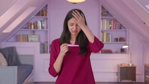 Stressed Indian woman taking pregnancy test