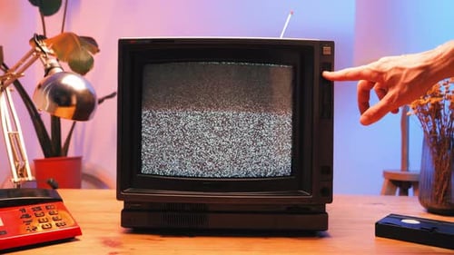 Hand Changing Channels on a Retro TV