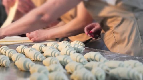 Bakers Preparing Fresh Croissants in a Commercial Kitchen