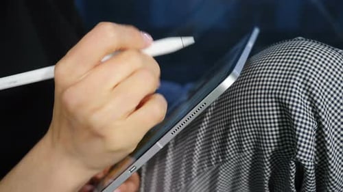 Adult Using Stylus on Tablet for Digital Art