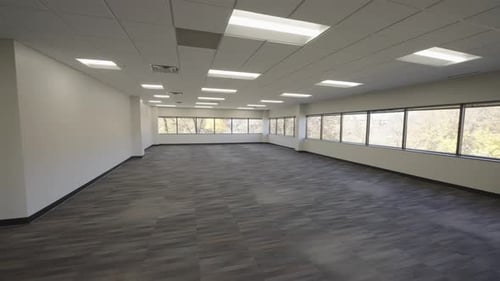 Bright Vacant Office Space with Large Windows and Modern Flooring