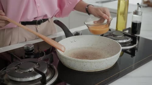 Person Cooking Eggs in a Kitchen