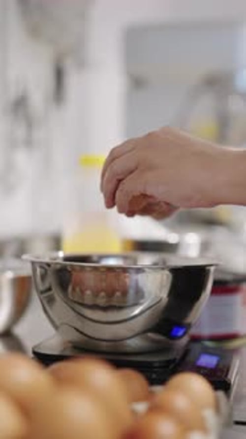 Pastry Chef Cracking Eggs Into a Bowl