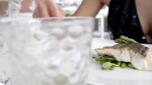 woman eating fish in restaurant