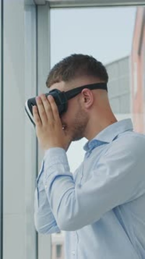 Close Up Young Man Sitting at a Desk in the Office Uses Augmented Reality Glasses to Work on