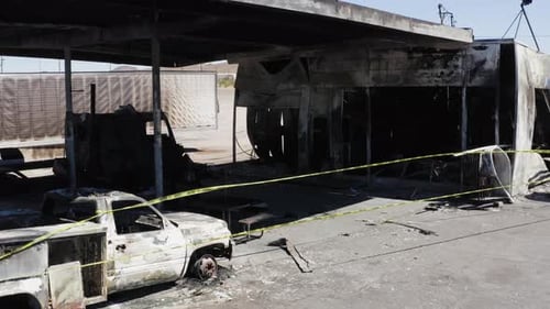 Burnt down gas station roped of with yellow crime tape.