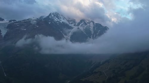 Aerial View of Towering Snowcovered Mountain Peaks with Mist