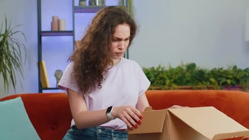 Woman Opens Box with Frustrated Expression