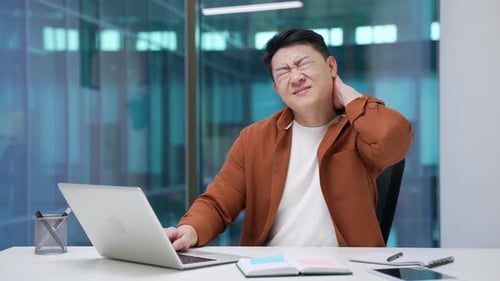 Man Rubbing Stiff Neck While Working at Computer