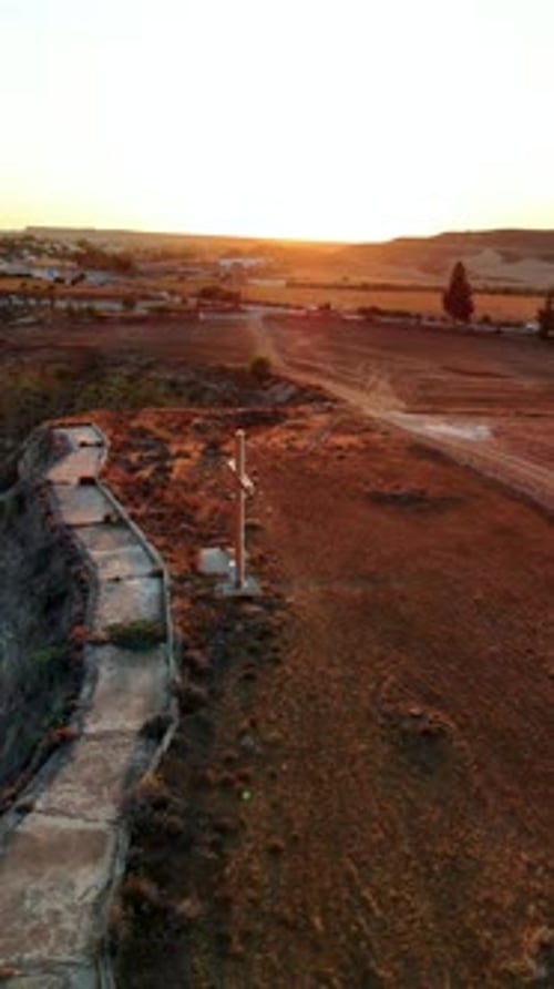 Scenic sunset view over the plains with a cross overlooking the landscape in a rural setting