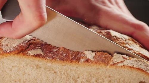 Slicing Fresh Bread with Knife Close Up
