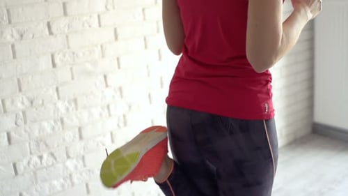 Woman Doing Leg Workout in Front of Brick Wall