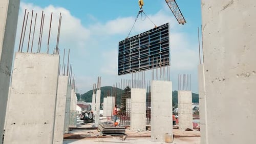 Construction of a Multistory Building a Crane Has Lifted a Large Slab 2 Construction Workers Work on