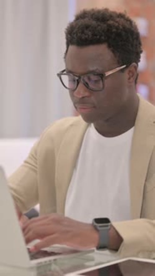Focused Young Man Working on Laptop in Office
