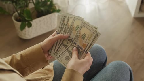 Woman Counting Money with Hundred Dollar Bills