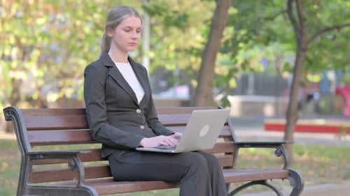 Businesswoman Working on Laptop in Park