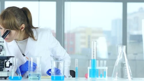 Female Scientist in Laboratory Reading Documents Paperwork of Result of Rese