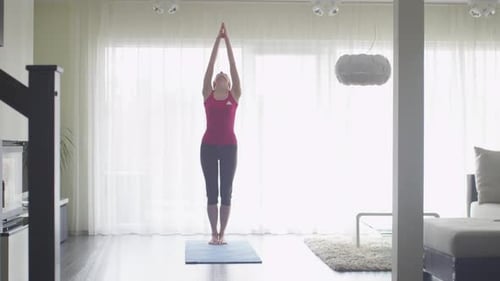 Woman Doing Yoga Exercises on Mat at Home