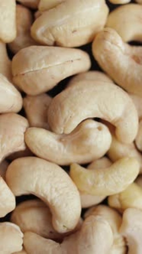 Cashew Pieces on a Turntable From Overhead Plant Based Ingredient Dried Cashew Nuts Vertical Video