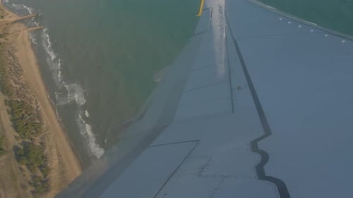 Airplane flying over the sea wing view