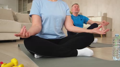 Senior Couple Meditating at Home in Bright Light