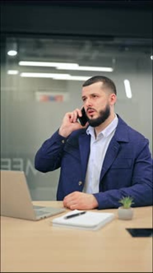 Professional Man Communicating on Phone in Modern Office