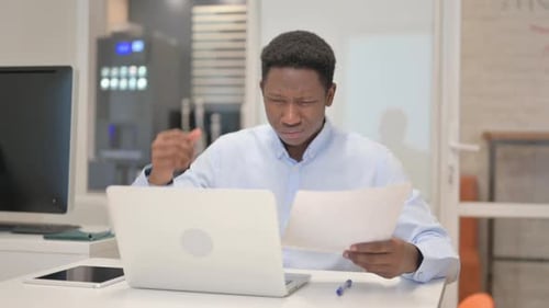 Young Adult Working on Laptop in Office