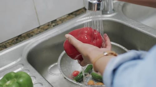 Hands Washing Fresh Vegetables in Kitchen Sink