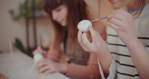 Mother and Daughter are Painting Easter Eggs for Easter Holidays