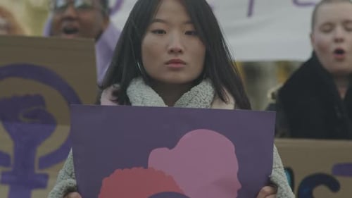 Portrait of Young Asian Woman with Feminist Poster on Strike