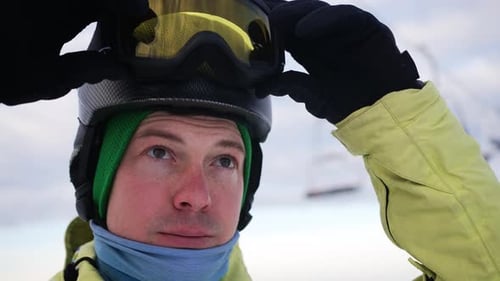 Skier Adjusting His Ski Mask and Goggles on the Slopes