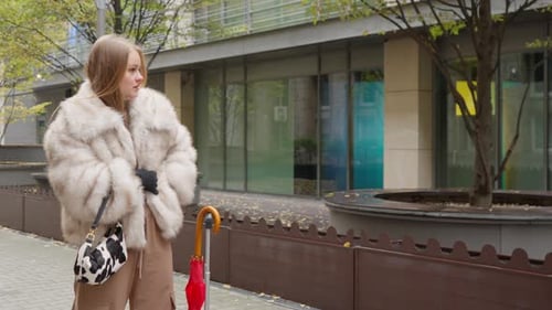 A female tourist putting on gloves during a chilly autumn walk in a city