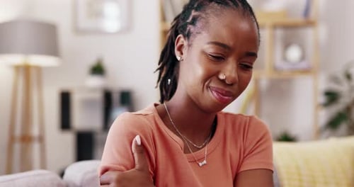 Young Adult Holding Arm in Pain Indoors