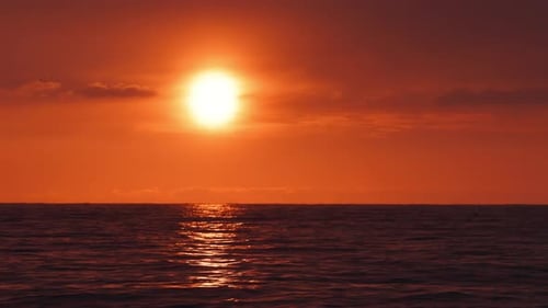 Coucher de soleil orange à couper le souffle sur la mer avec des teintes orange vibrantes et se reflétant sur des vagues calmes