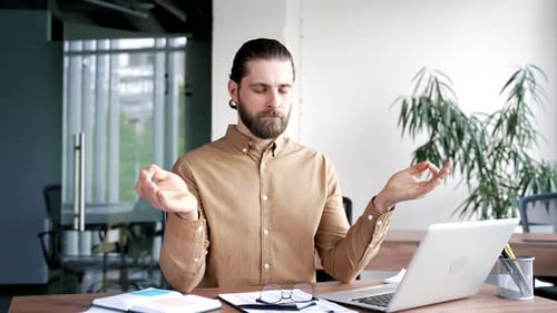 Man Meditating at His Desk in Office
