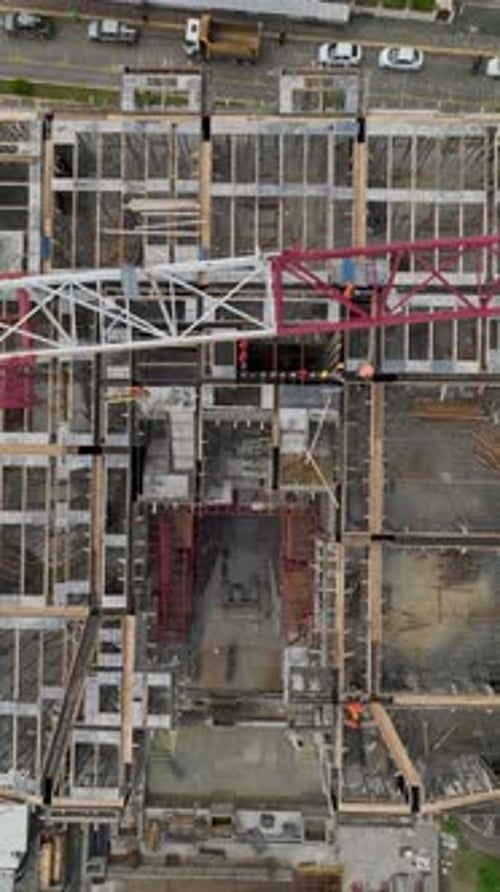Vertical Video of Crane Lifting Concrete Blocks to Upper Floors