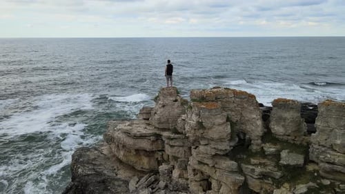 aerial man rocks sea